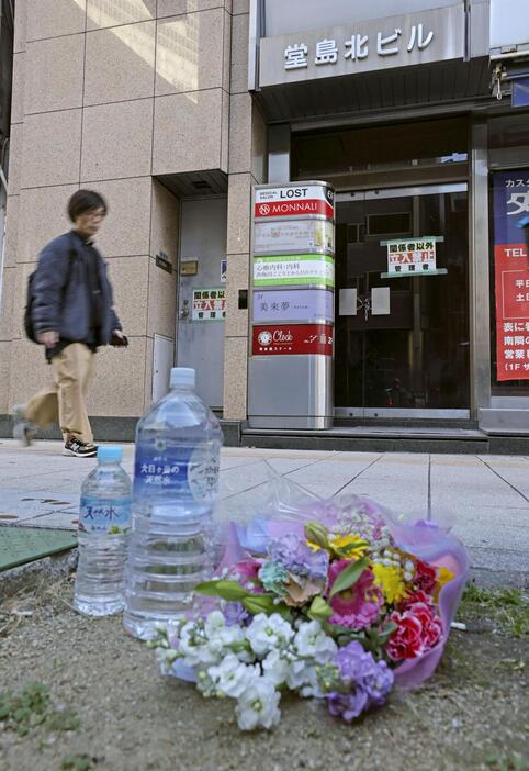 大阪・北新地の放火殺人事件から3年、ビルの前に供えられた花束＝17日午前