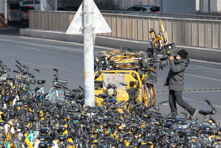 北京市内の通りでシェア自転車を移動させ、市民の交通利便性を確保するシェア自転車の運用員（2023年1月21日撮影、資料写真）。