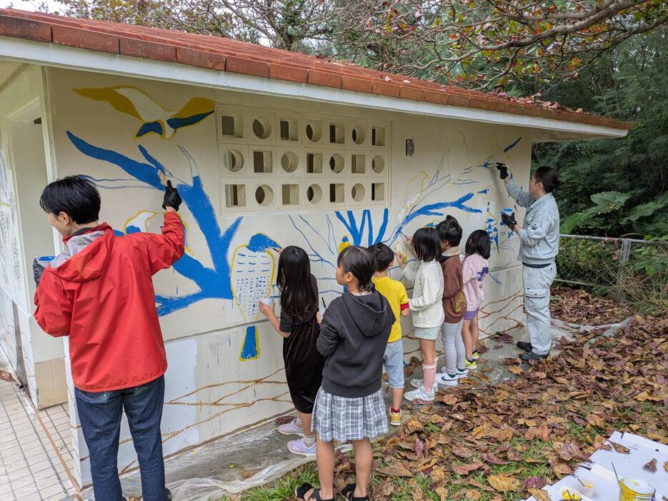 トイレの壁に絵を描く子どもら＝14日、北中城村の渡口多目的広場