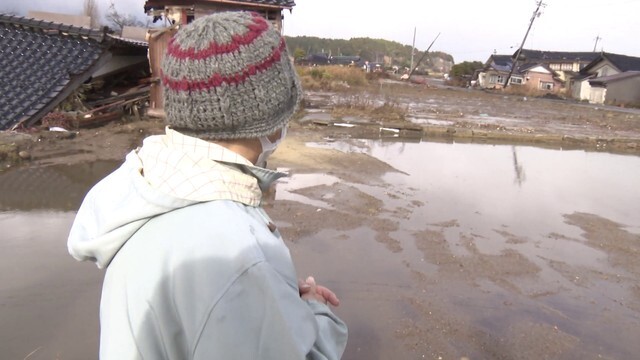 自宅跡を眺める英子さん