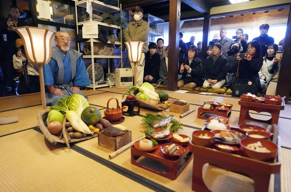 奥能登の農家に伝わる農耕儀礼「あえのこと」で「田の神様」に酒やごちそうを振る舞う小山栄さん。日本の「伝統的酒造り」や「あえのこと」はユネスコの無形文化遺産に登録されている＝5日午後、石川県輪島市三井町