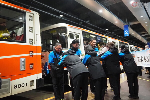 室堂を出発する前に花束を贈られる立山トンネルトロリーバスの最終便運転士ら（2024年11月30日、大塚圭一郎撮影）。