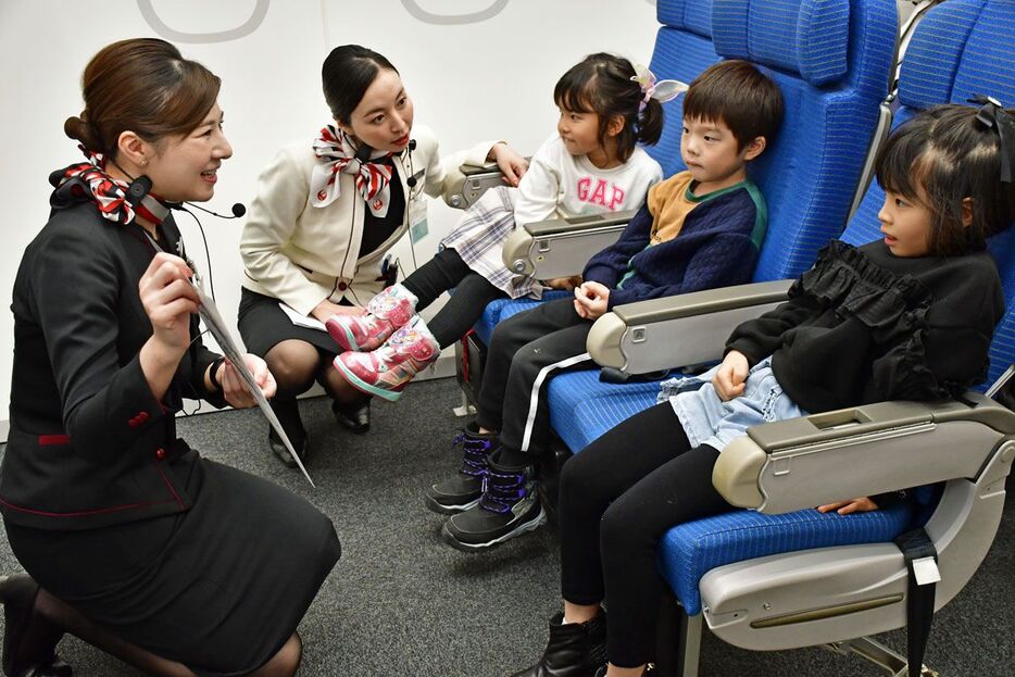 CAの（左から）一色さん、永井さんから優しく指導を受ける子どもたち