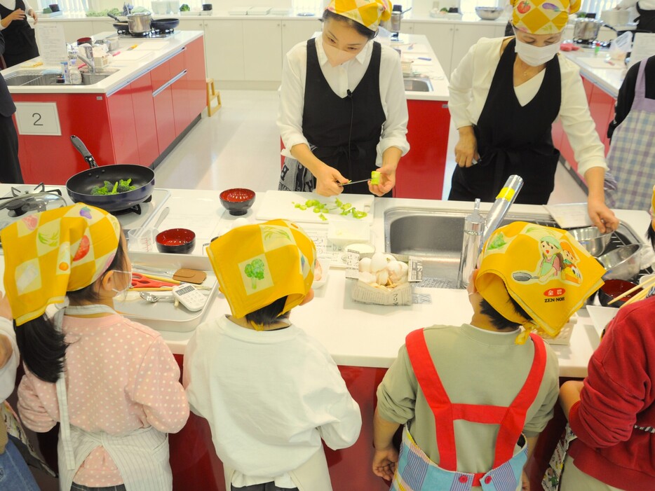 「全農親子料理教室」で講師の手本を見つめる子どもたち＝横浜市のJA横浜「クッキングサロン ハマッ子」、2024年12月21日