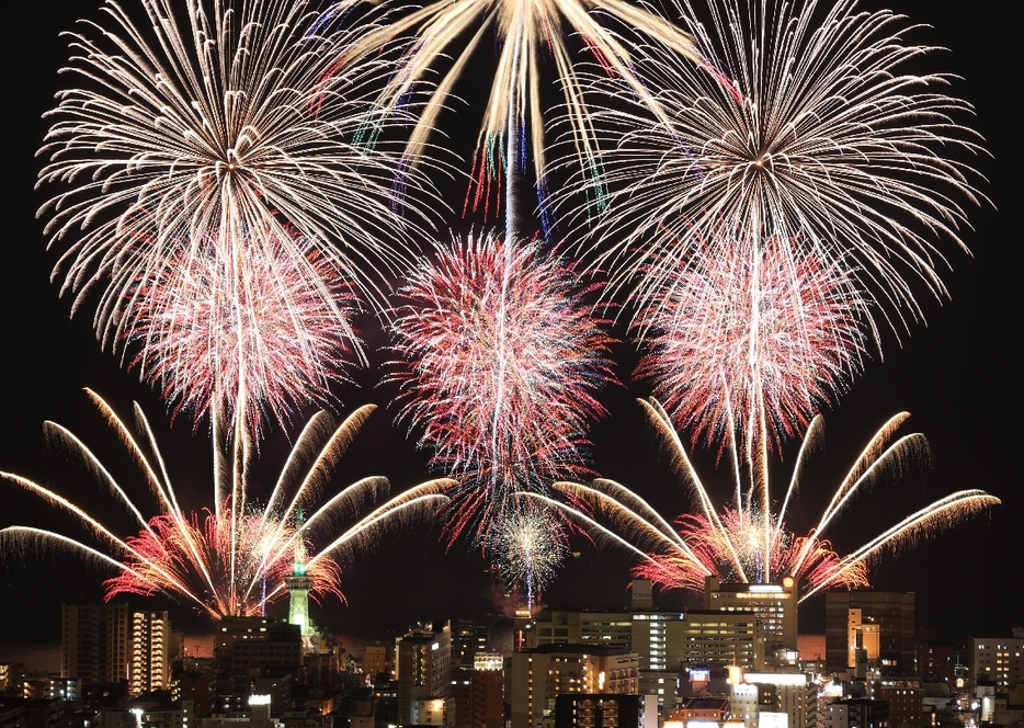 別府の夜空を彩る大輪の花火＝21日夜、別府市（2枚の写真を比較明合成）