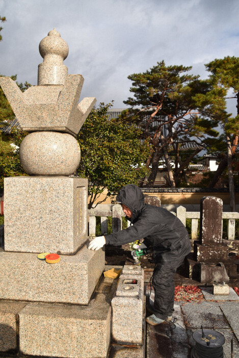 大隈重信と妻綾子の墓の水あか除去をする人＝佐賀市赤松町の龍泰寺で2024年12月21日午前9時35分、西脇真一撮影