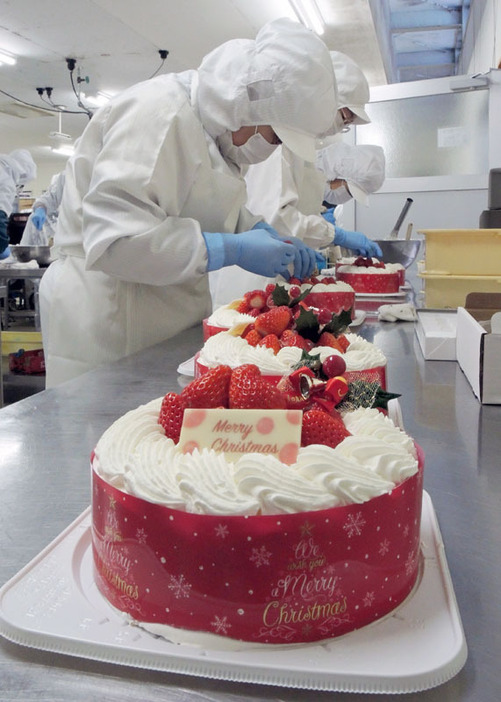 イチゴや飾りが載せられ、次々と仕上げられるクリスマスケーキ＝平泉町の松栄堂本社工場