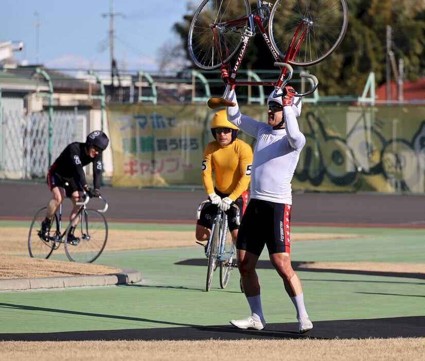 レース後のスタンドからの声援に自転車を掲げて応える神山雄一郎