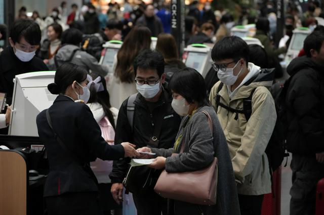 羽田空港第1ターミナルの日本航空のチェックインカウンター前の利用者ら=2024年12月26日午前10時40分、小林一茂撮影