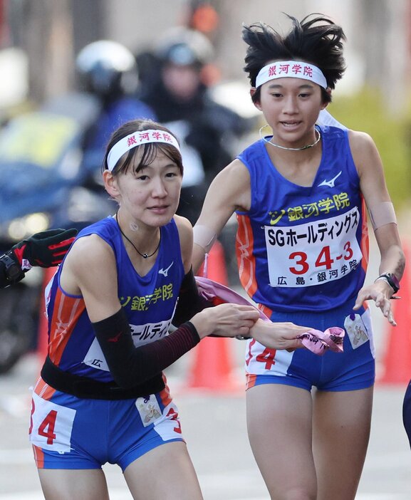 銀河学院の3区山根㊨からたすきを受け走り出す4区川手