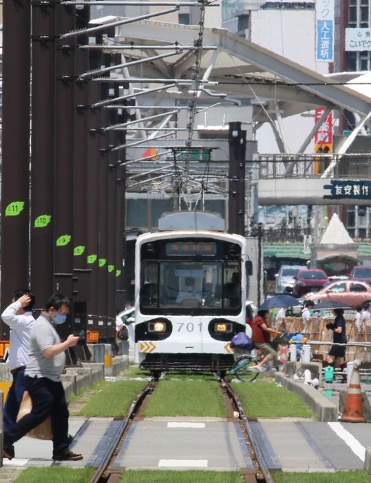 ［写真］路面電車の駅前も陽炎が立ち込めて暑さが増してみえ、パンダのイラストが描かれた車両も少しぼやけてみえる＝6日午後1時半ごろ、大阪市阿倍野区で