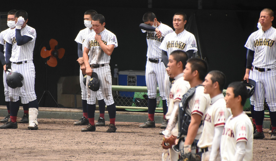 県独自大会決勝で倉吉東に敗れ、相手の校歌を聞きながら涙を流す鳥取城北の選手たち（奥）＝鳥取市のコカ・コーラボトラーズジャパンスポーツパーク野球場で