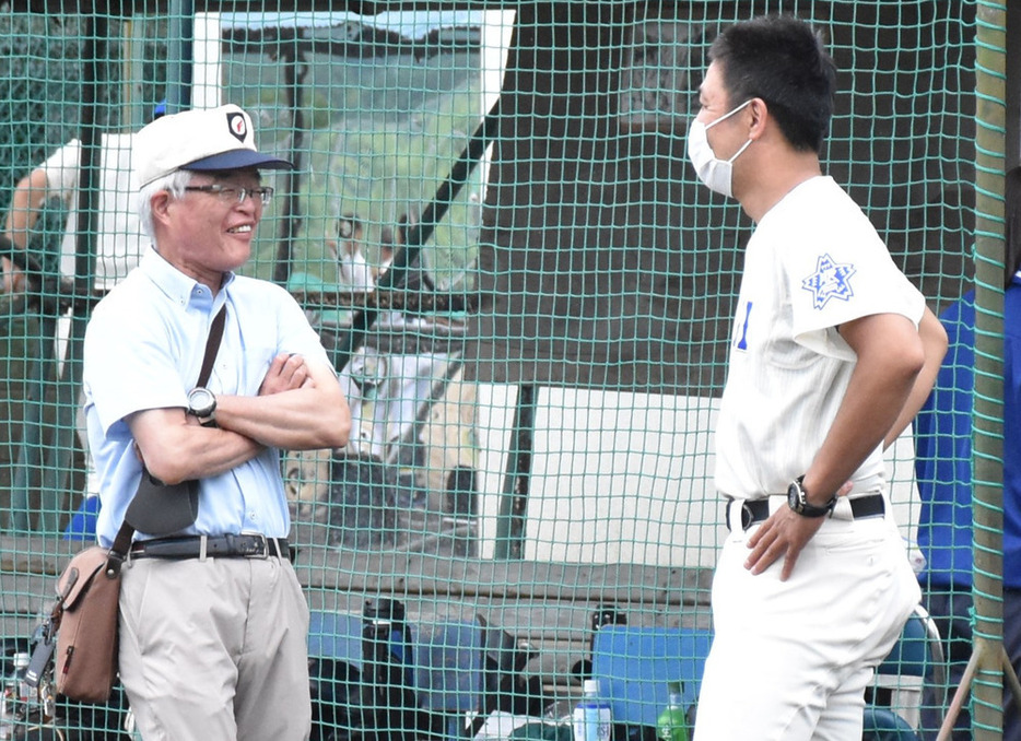 練習試合で渡辺純監督と談笑する阿部武彦前校長（左）。３月末で定年退職後、いわき光洋高の常勤講師と野球部顧問を務めている＝福島県いわき市の磐城高グラウンドで