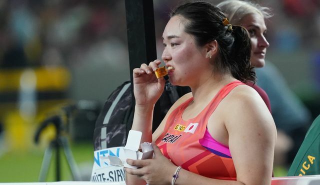 競技会場でカステラを食べる北口榛花選手(写真：アフロ)