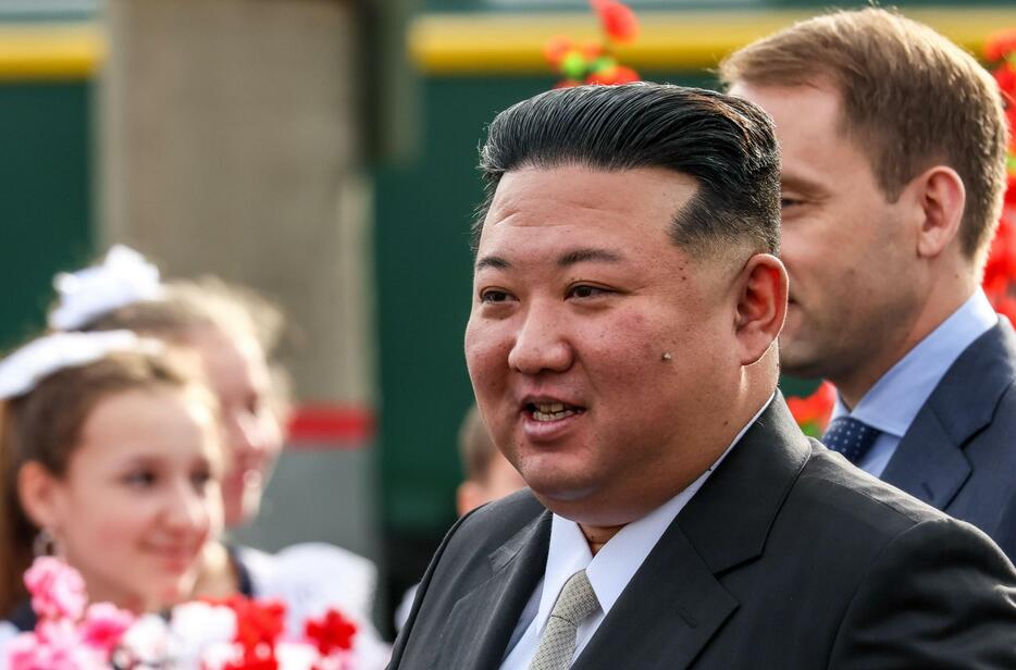16日、ロシア極東アルチョムの駅で歓迎を受ける北朝鮮の金正恩朝鮮労働党総書記（タス＝共同）