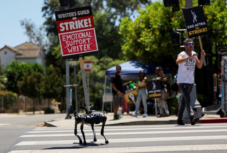 8月、ストライキ中に、プラカードを掲げて歩くロボットの犬＝ロサンゼルス（ロイター＝共同）