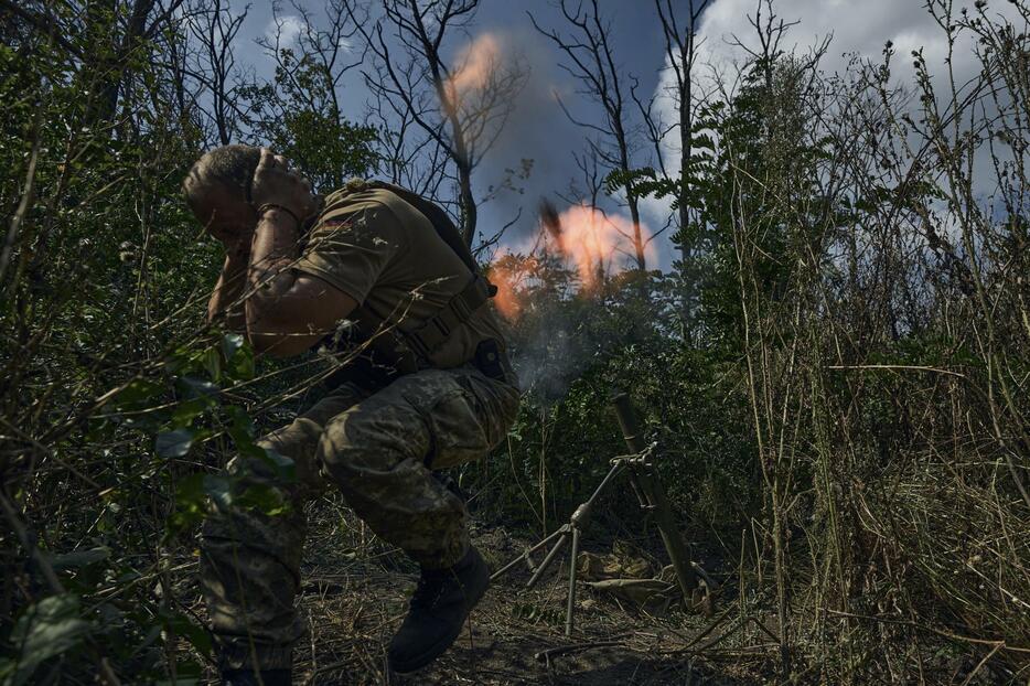 ウクライナ東部バフムト近くで、ロシア軍陣地に向けて迫撃砲を撃つウクライナ兵＝2日（AP＝共同）