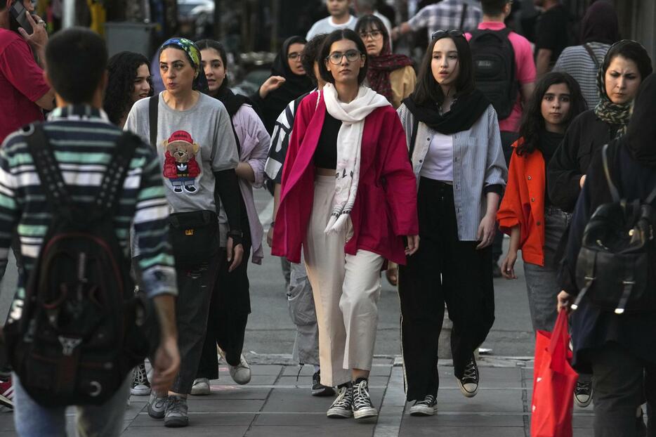スカーフを着用せずにテヘランの街中を歩く女性たち＝9日（AP＝共同）