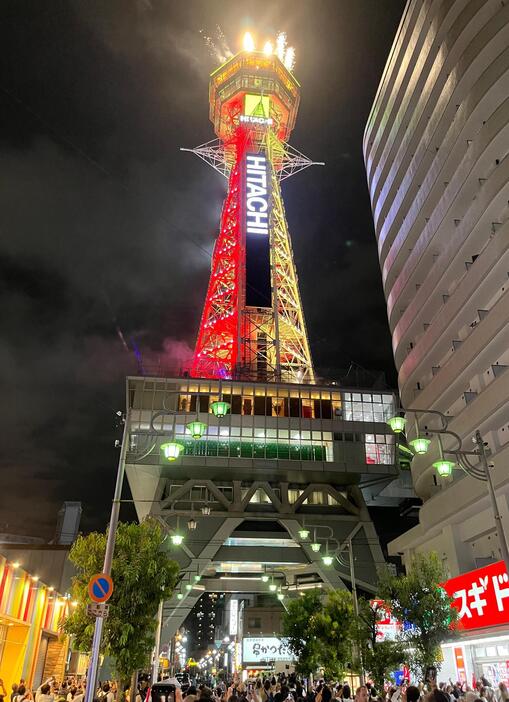 ［写真］花火とともに久々に輝きを放つ通天閣。周辺には点灯の瞬間を撮ろうと多くの観光客らが携帯電話のカメラを構えていた＝22日午後6時40分ごろ、大阪市浪速区で