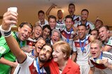 ドイツ代表が2014年W杯で優勝を飾った直後の一枚。彼ら多くのスター選手がメルケル首相（右下）の何十倍もの報酬を得ている現状は、はたして健全と言えるのか。(C) Getty Images