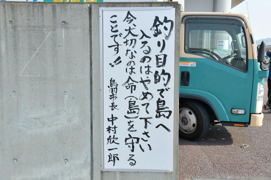 三重県鳥羽市の鳥羽マリンターミナル。緊急事態宣言後も釣り目的に離島に渡る人が絶えないことから、市長名で注意喚起する看板が貼られた（5月2日午前8時ごろ、加藤直人撮影）