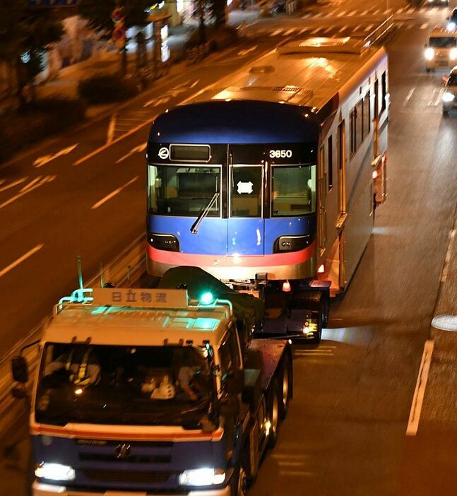 [写真]トレーラーに載せられて輸送中の大阪モノレール新型車両（撮影：伊原薫）