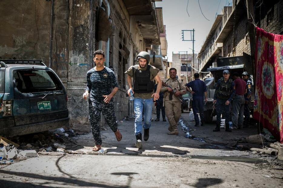 [写真]激戦の続くモスル旧市街地でスナイパーのいる通りを駆け抜けるマジッド