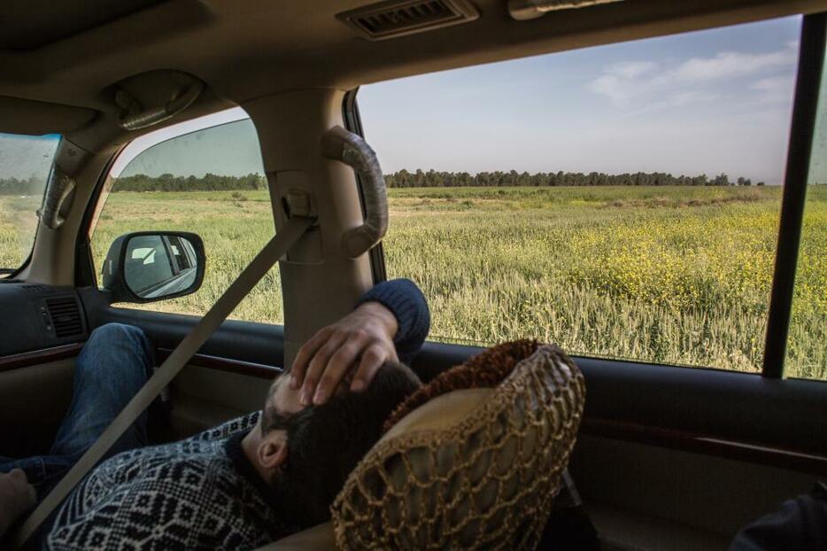 [写真]モスルに向かう道中、疲労から仮眠をとるマジッド