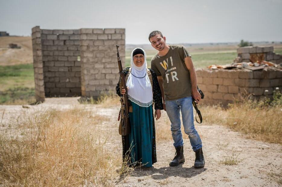 [写真]ISと戦うモスル郊外の村の住人と一緒に笑顔を見せるマジッド