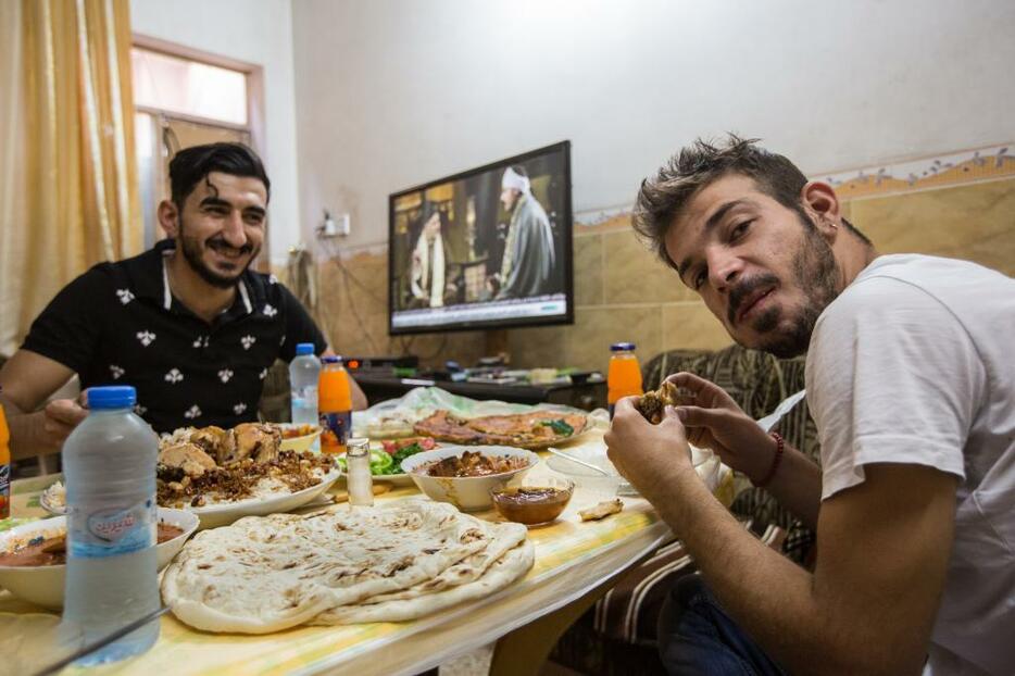 [写真]モスル市内の友人の家を訪ね、ご馳走で歓迎されるマジッド