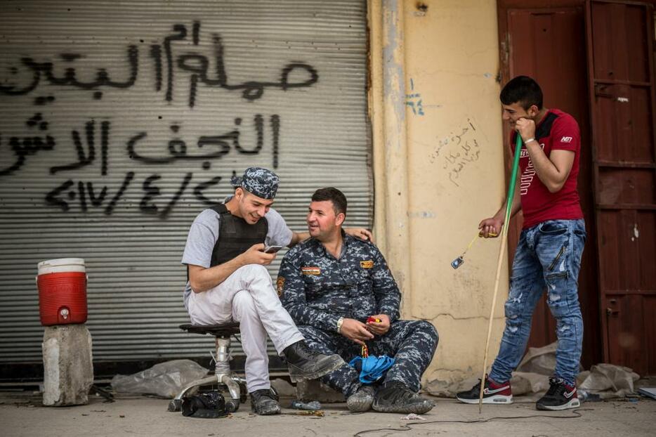 [写真]モスル旧市街地で警察軍のメディア担当官と親しげに話すマジッド