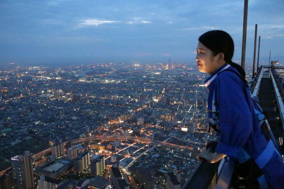 [写真]夕暮れの風景。案内担当の女性は「最初は怖かったけどもう慣れました」と笑顔をみせる。「高い建物が少ないので、夜景を堪能できます」と教えてくれた＝11日午後7時半ごろ、大阪市阿倍野区で（撮影：柳曽文隆）