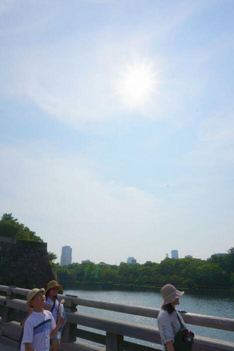 [写真]照りつける太陽に思わず天をあおぐ人も=17日午後3時すぎ、大阪市中央区で