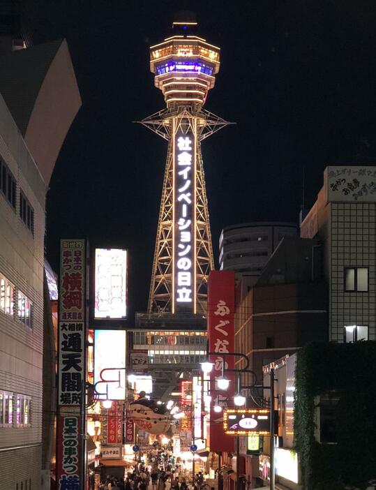 ［写真］新世界に訪れた多くの人も点灯を見守っていた＝12日午後8時すぎ、大阪市浪速区で