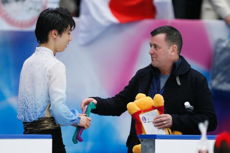 羽生を迎えるブライアン・オーサーコーチとクマのぬいぐるみ＝2015年11月27日（写真：田村翔/アフロスポーツ）