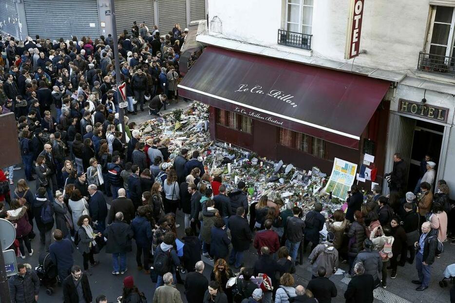 [写真]13日に発生した同時テロの現場となったレストラン前で被害者を悼むパリ市民ら（ロイター/アフロ）