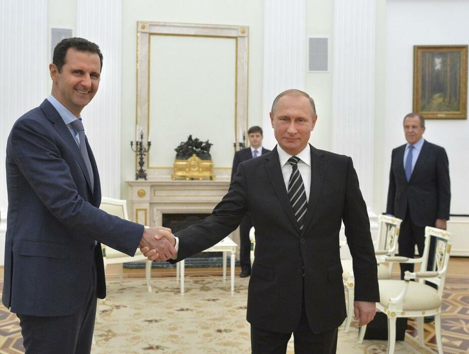[写真]シリア空爆をめぐる協議で訪露したアサド大統領（左）。プーチン大統領に空爆への謝意を表した（Kremlin/RIA Novosti/ロイター/アフロ、10月20日撮影）