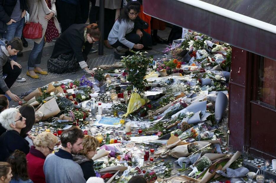 [写真]パリ同時多発テロで襲撃された現場に花をたむけて犠牲者を悼むパリ市民ら（ロイター/アフロ）