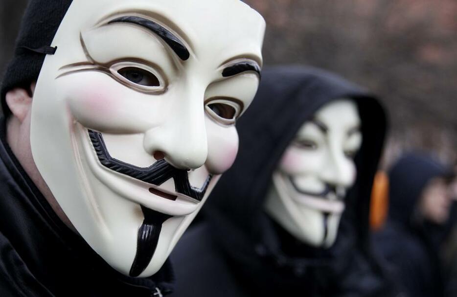 [写真]ガイ・フォークスの仮面を被って抗議デモをする参加者。2012年には欧州各地でデモが行なわれた（ロイター/アフロ）