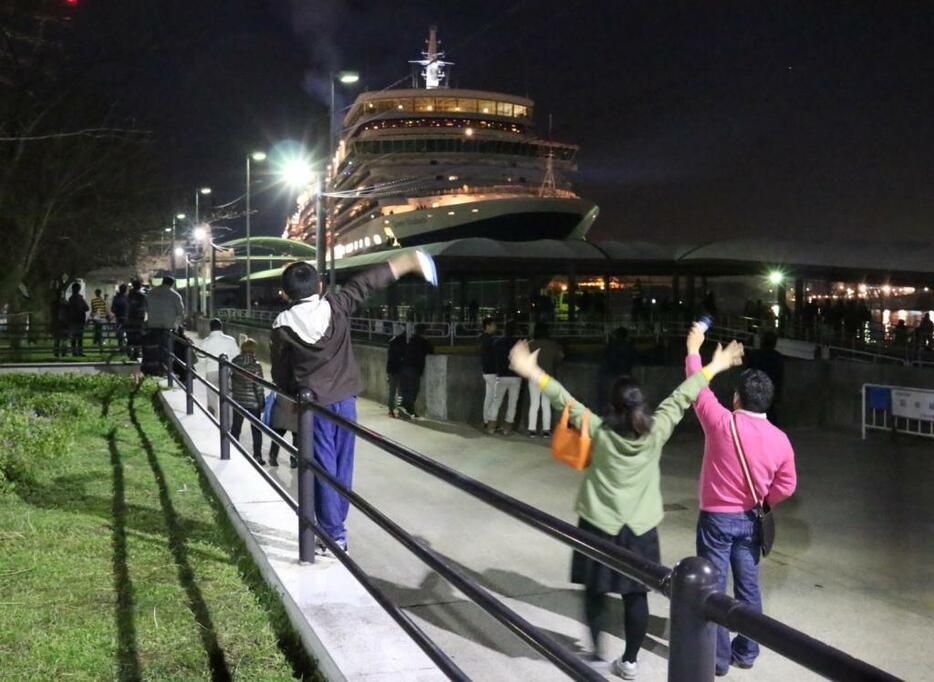 ［写真］クイーンエリザベスが大阪港を離岸。多くの見物人が懸命に手を振り、船の乗客らも振り返していた＝22日午後11時10分ごろ、大阪市港区で
