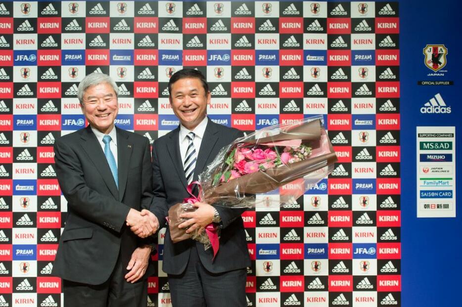 記者代表から花束を受け取り、大仁会長（左）と握手するなでしこ佐々木監督（右）（撮影：山本宏樹/DELTA　PHOTO）