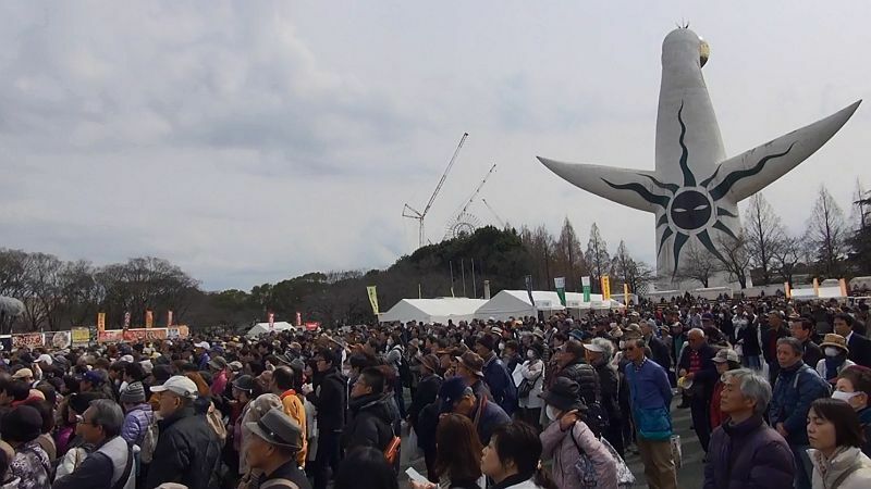 [写真]太陽の塔の後方はお祭りでにぎやかに