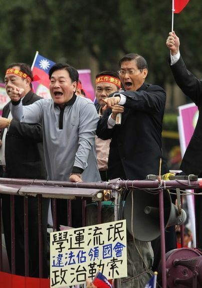 [画像]立法院を占拠する学生らに反対するデモを呼びかけた張安楽氏（写真右）4月1日、地元紙「アップルデイリー」撮影