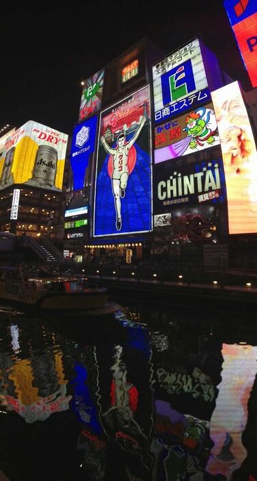 [写真]現在の5代目看板。道頓堀川の水面にも映る＝11日午後、大阪市中央区で