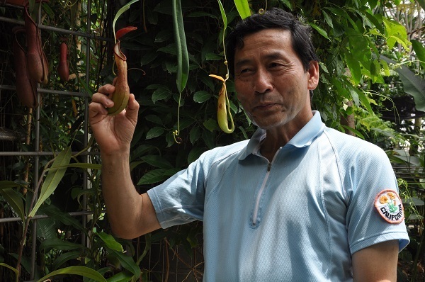 [写真]ウツボカズラを手に食虫植物の魅力を語る久山敦・咲くやこの花館館長